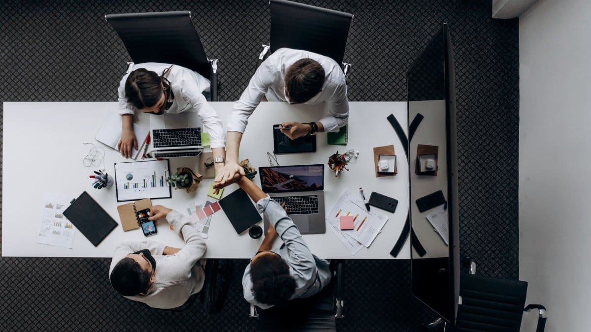 High angle view of colleagues collaborating around a conference table in a modern office setting.