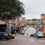 View of the historic Fort Worth Stockyards with bustling street and classic architecture in Texas.