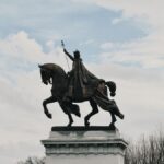 Equestrian statue of King Louis IX in St. Louis, Missouri under a partly cloudy sky.