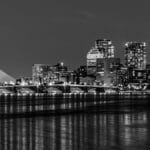 Elegant black and white night view of Boston's illuminated city skyline over Charles River.