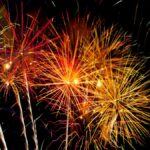 Colorful fireworks explode in the night sky, creating a vivid display of light and color.