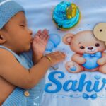 Adorable baby sleeps next to a cupcake, marking their first month milestone. Perfect for newborn themes.