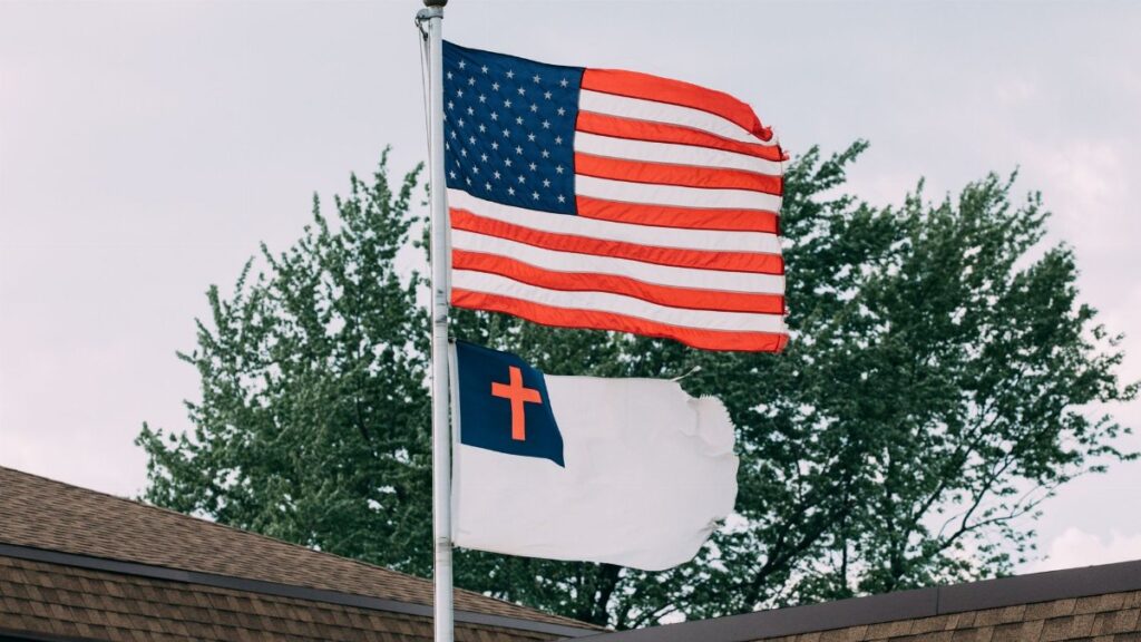 Patriotic display of American and Christian flags on rooftop in Springfield, IL.