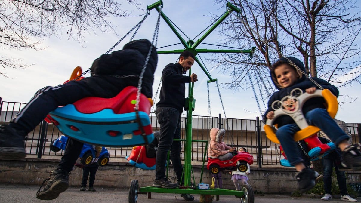 Kids having fun on a colorful carousel in a park setting. Outdoor play and joy.