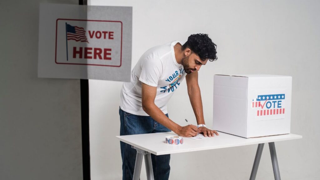 A young man at a polling station voting on election day, symbolizing democracy.