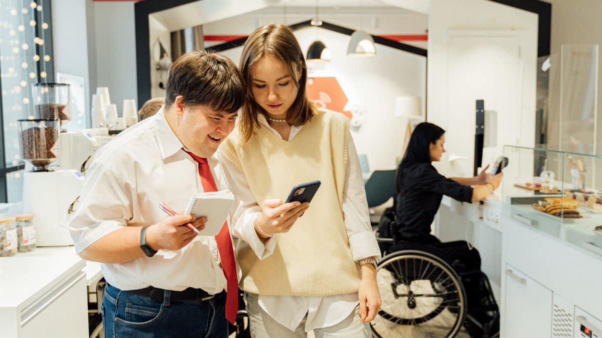 A diverse group in a coffee shop shows inclusivity and accessibility with attentive customer service.