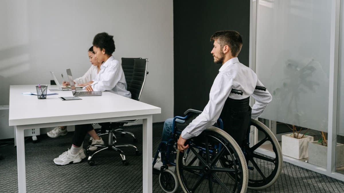 Diverse team in an office meeting, focusing on inclusive workplace and accessibility.