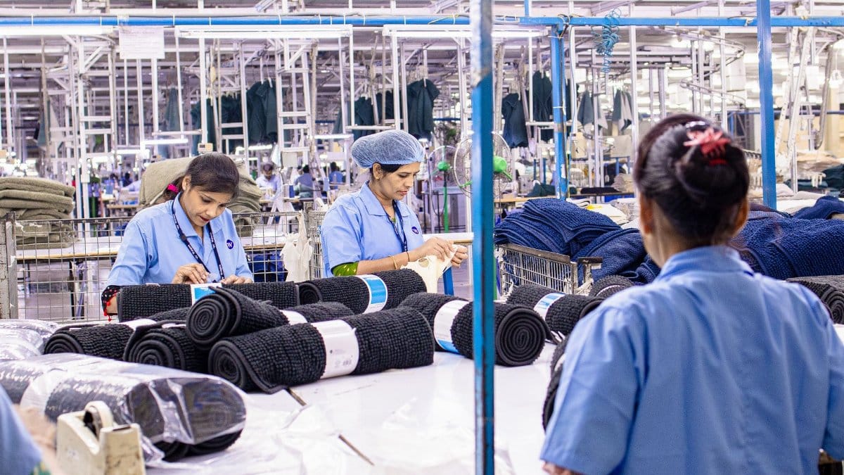 Female workers sorting fabric in a large textile factory setting, showcasing industry and teamwork.