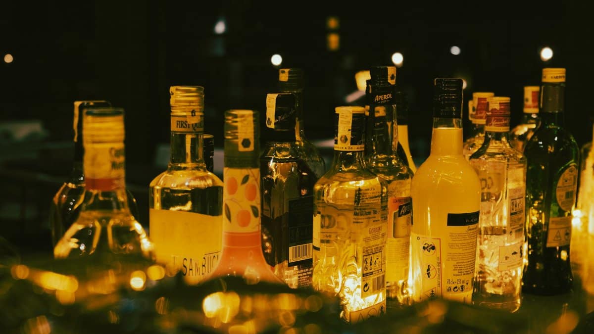 A lively close-up of assorted alcohol bottles illuminated in a dimly lit setting, creating a vibrant atmosphere.