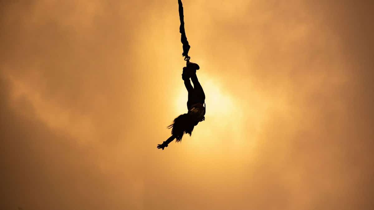 Silhouette of a lone bungee jumper against a vibrant sunset sky in Johannesburg, South Africa.