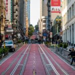Vibrant street view of San Francisco with people, shops, and iconic signs.