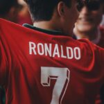 A passionate soccer fan wearing a Ronaldo jersey celebrates at a sports event.