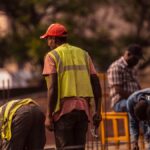 Group of male construction workers on site wearing safety gear during daytime.