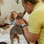 Caring staff and elderly enjoy moments of joy with therapy pets in a retirement home.