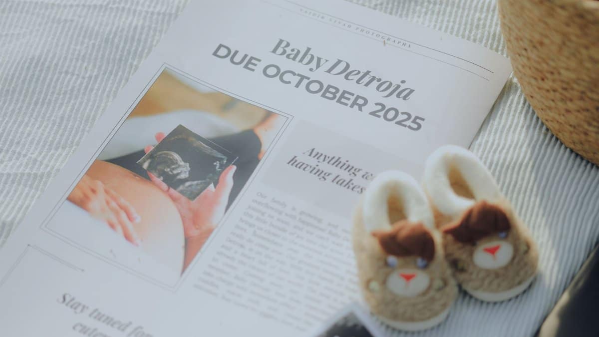 Creative flat lay of pregnancy announcement with ultrasound and baby shoes.