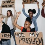 A diverse group of activists holding protest signs in a studio setting, advocating for human rights and justice.