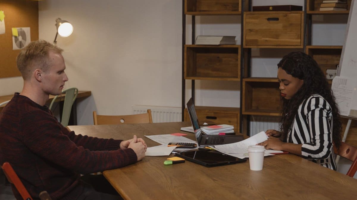Two professionals engaged in a business meeting at a modern office, discussing strategies.
