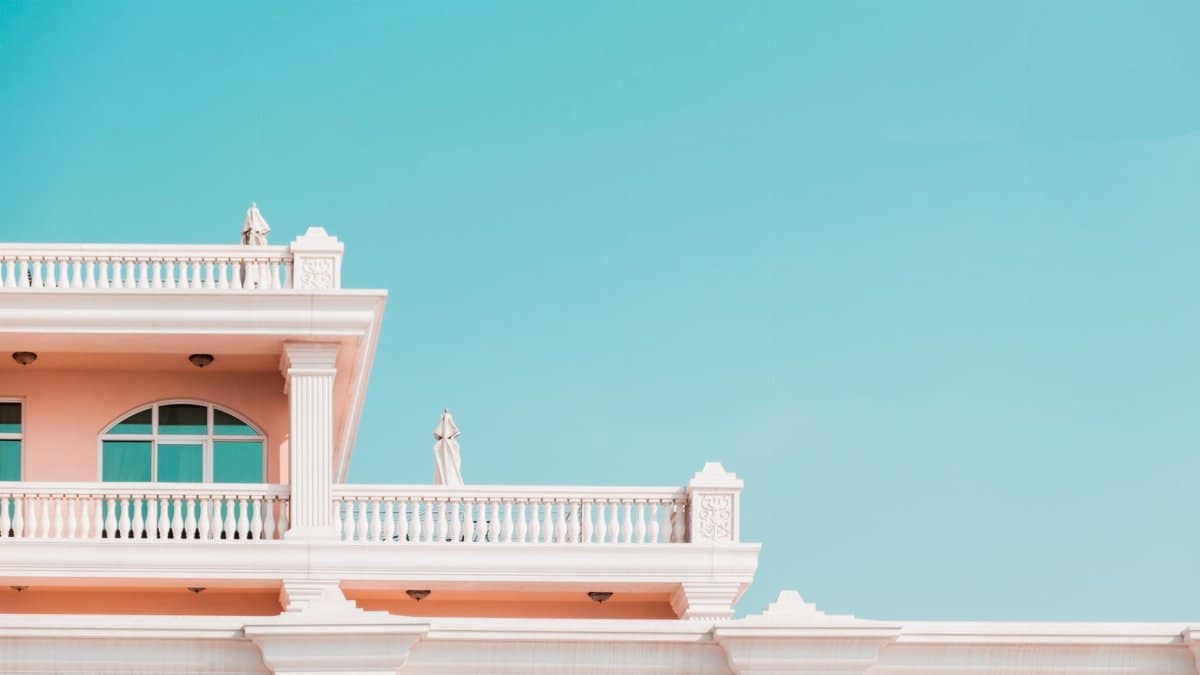 Traditional building facade with balconies against a clear blue sky, showcasing classic architectural design.