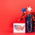 A festive display of red, white, and blue patriotic decor against a vibrant red background, perfect for July 4th celebrations.