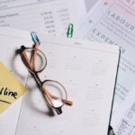 A calendar marked with "Tax Deadline" surrounded by financial documents and eyeglasses.