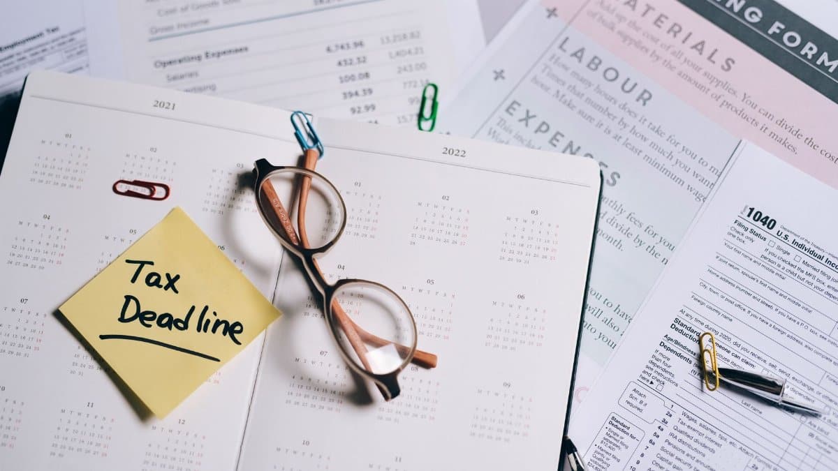 A calendar marked with "Tax Deadline" surrounded by financial documents and eyeglasses.