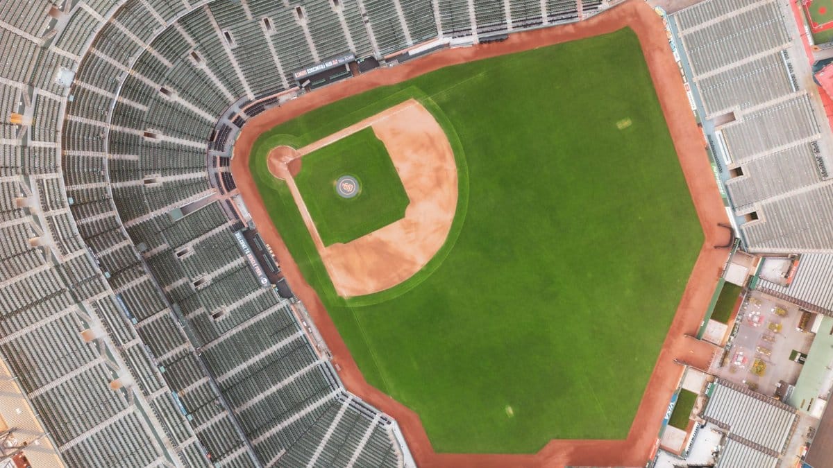 Drone shot capturing a top-down view of an unoccupied baseball stadium.