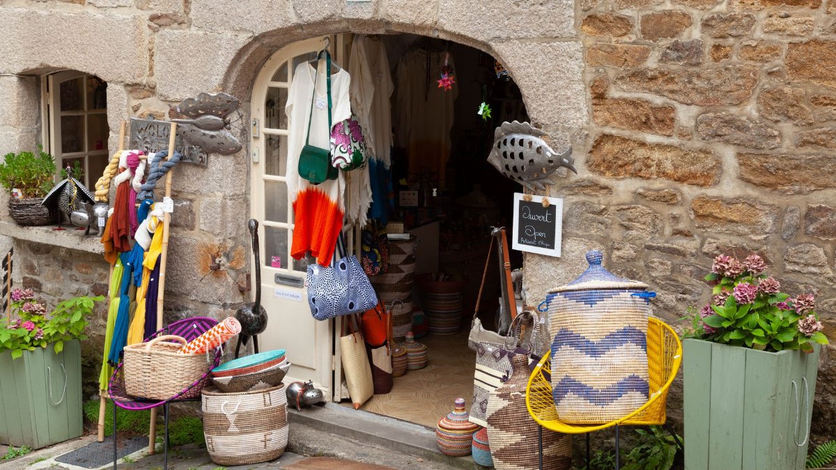 Colorful craft shop in Dinan, Brittany with baskets and textiles on display.