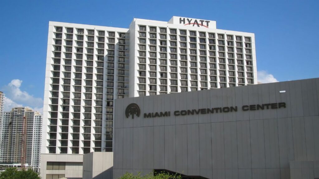 Exterior view of the Hyatt and Miami Convention Center under a clear blue sky.