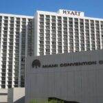 Exterior view of the Hyatt and Miami Convention Center under a clear blue sky.