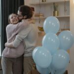 Couple celebrating new parenthood with friends at home during a gender reveal party.