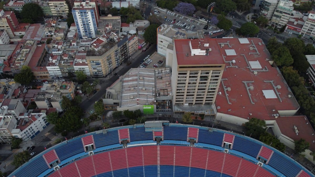 Drone shot capturing a stadium and urban landscape in Ciudad de México, showcasing buildings and city life.