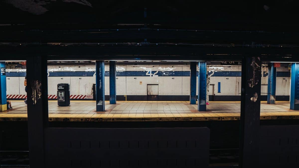 Empty subway platform with blue pillars at 42nd Street Station in New York City.