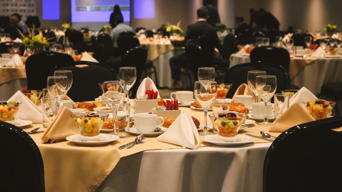 A beautifully arranged dining table set for an elegant banquet or event inside a restaurant.