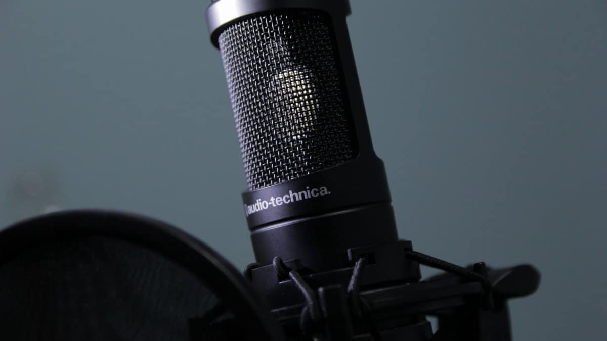 Detailed shot of a condenser microphone and pop filter, perfect for audio recording needs.