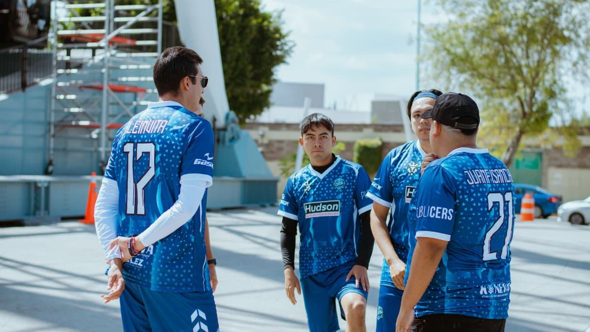 Group of young men in blue jerseys discussing strategy outdoors in Puebla, Mexico.