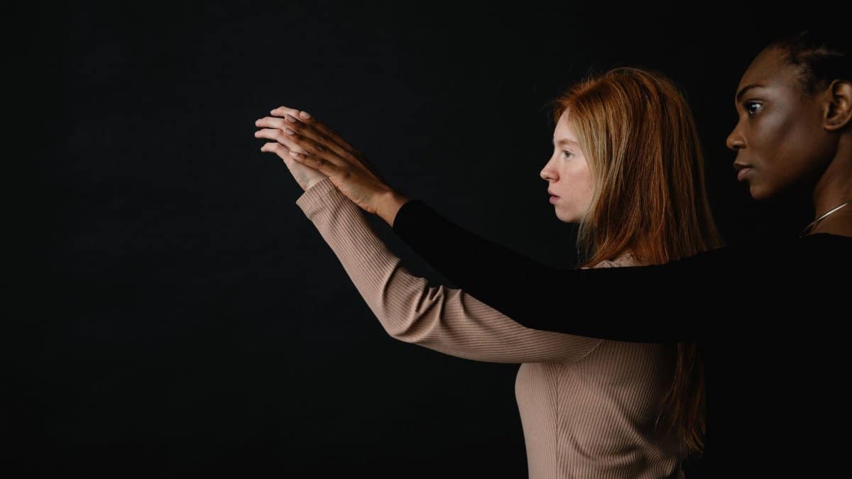 A conceptual portrait of two diverse women showcasing unity and connection on a dark background.