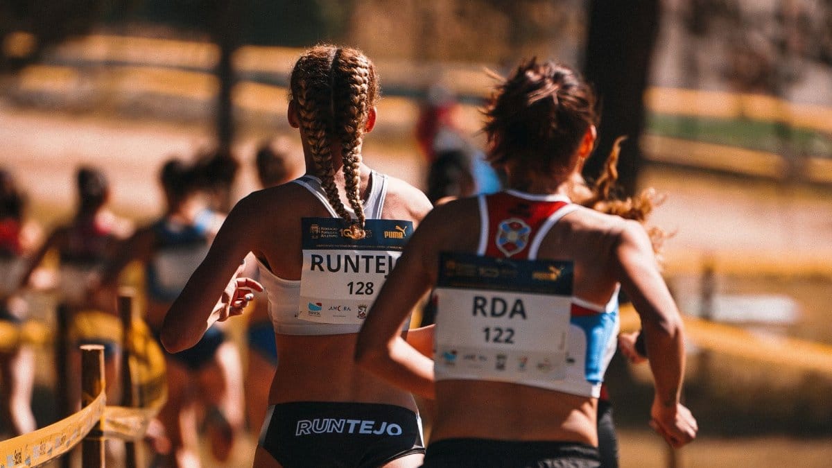 Two women athletes competing in a marathon with blurred background for dynamic effect.