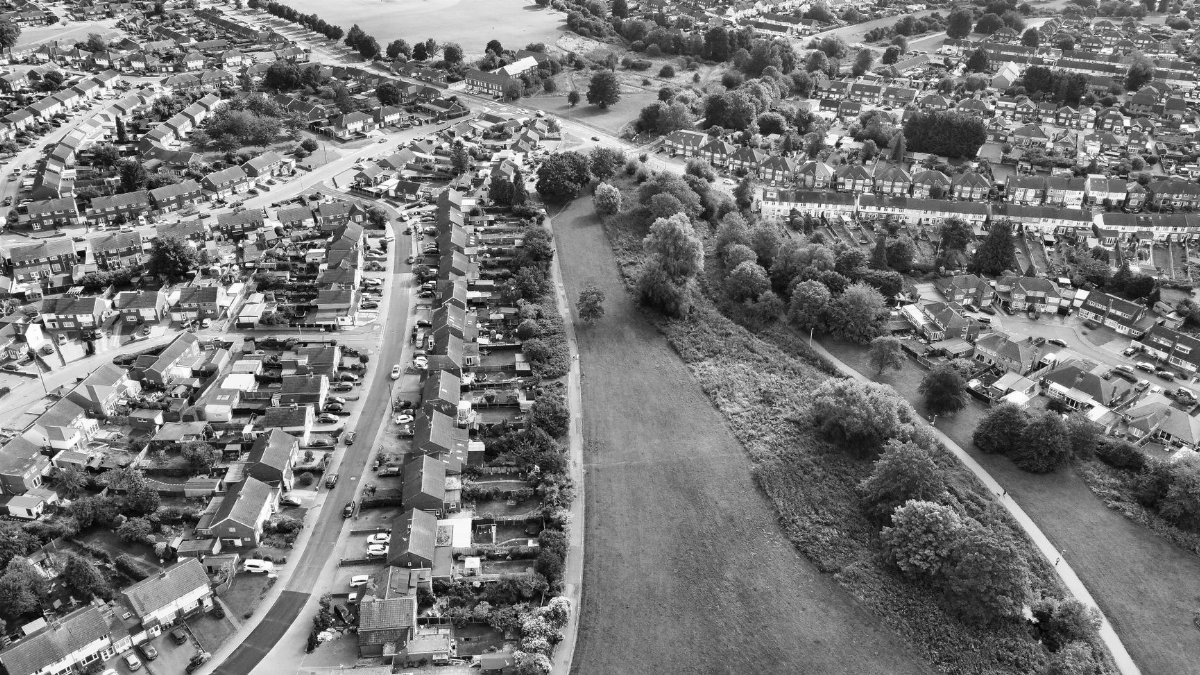 Aerial black and white photo of suburban Luton with residential streets and green spaces.