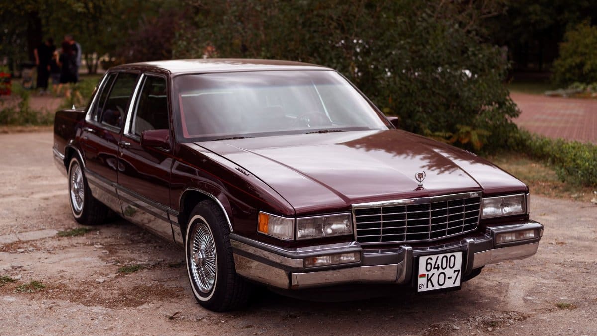 Luxury Cadillac DeVille parked outdoors on a sunny day, showcasing its classic design and elegance.