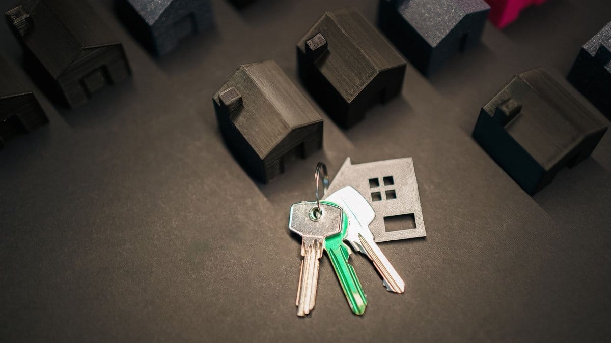 Miniature house models and keys symbolize real estate investment and housing market.