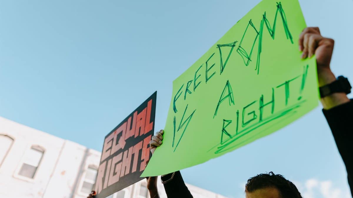 Protesters in a rally holding signs for equal rights and freedom.