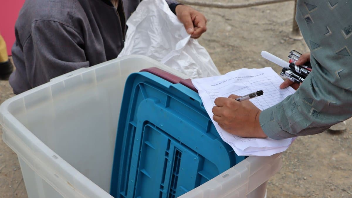 Election authorities managing ballot box during Nepal election.