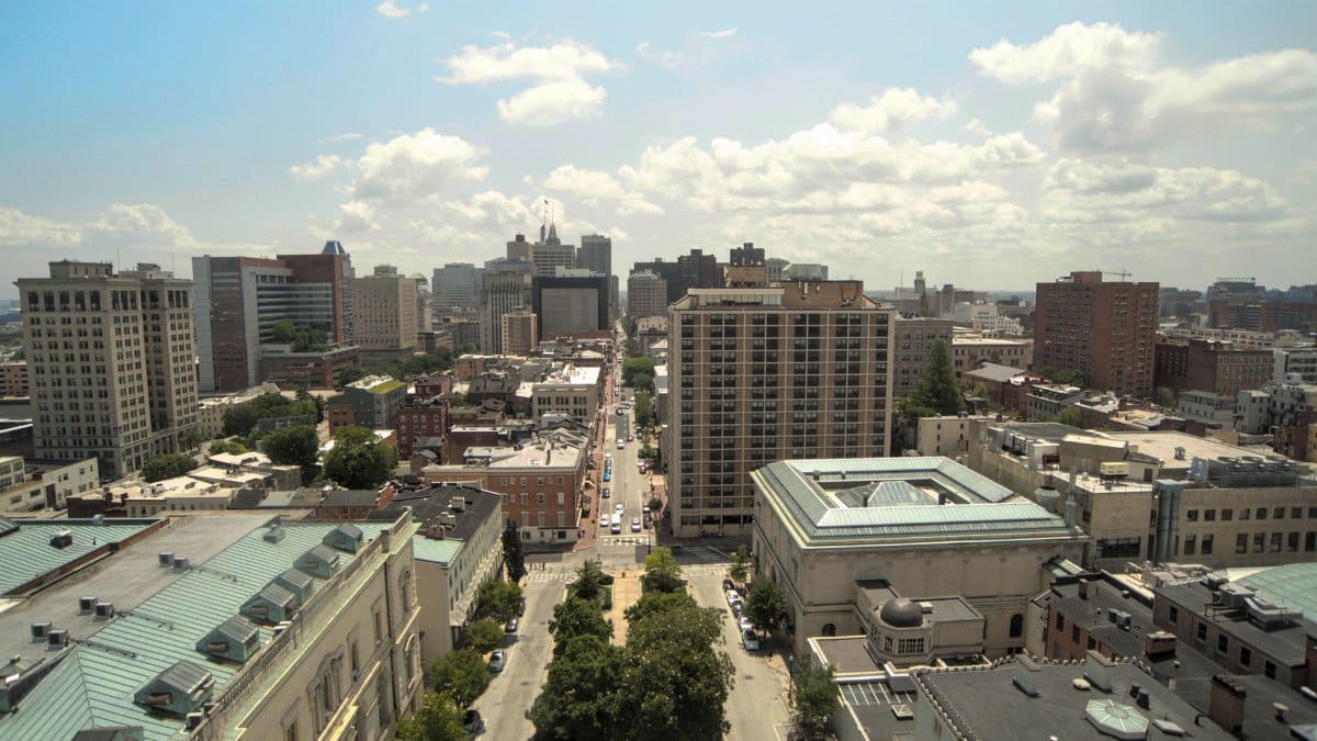 Aerial view of downtown Baltimore cityscape with historic architecture and skyline under clear skies.