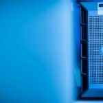 Close-up of a modern server unit in a blue-lit data center environment.