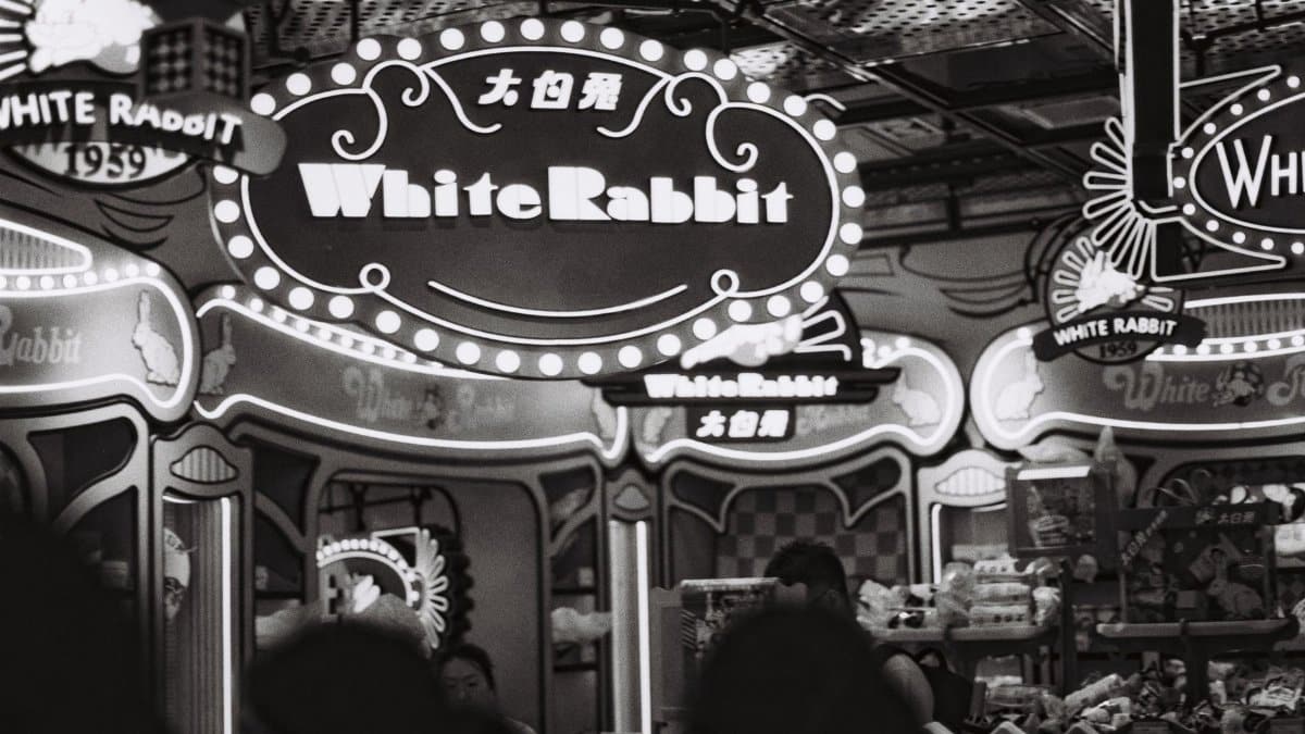 Vintage-themed candy store featuring White Rabbit brand signage in a busy market setting.