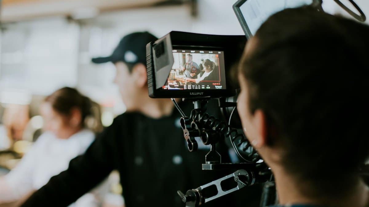 A behind-the-scenes look at a film crew capturing a scene with a focus on a monitor display.