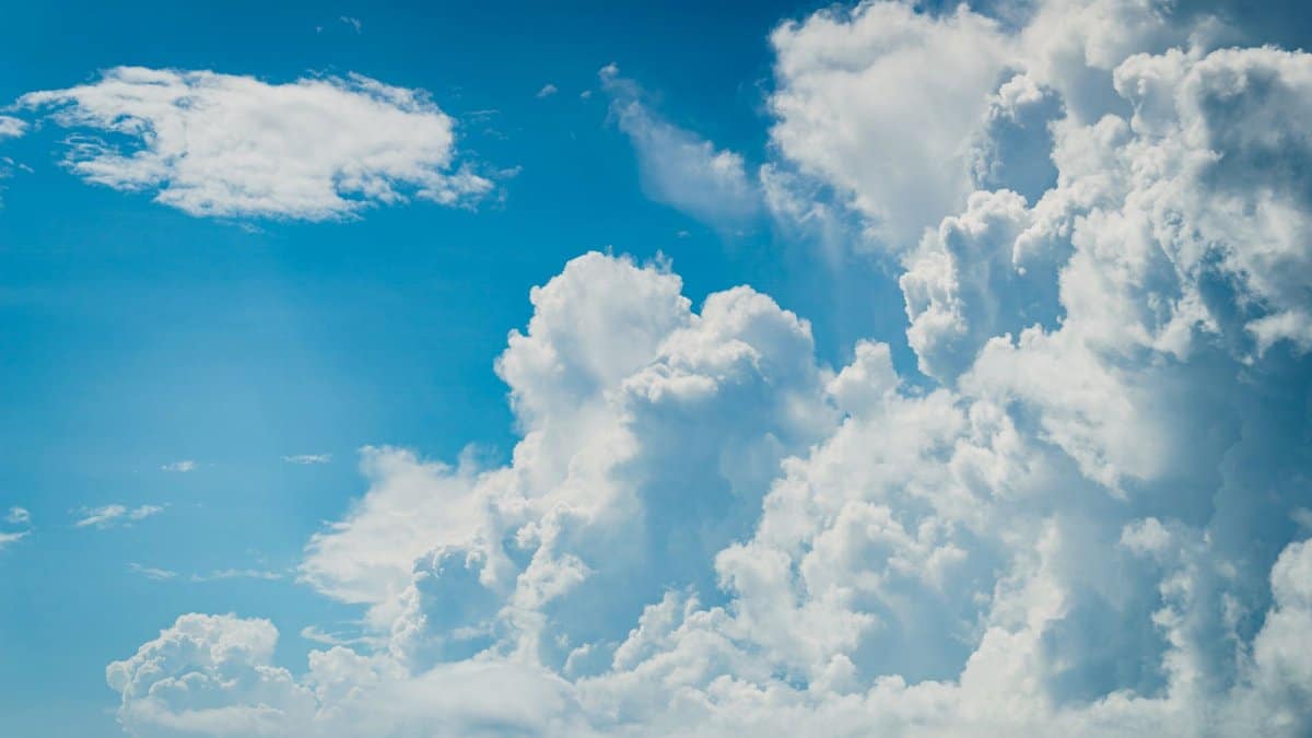 A vivid view of fluffy cumulus clouds against a bright blue sky, ideal for backgrounds or weather themes.