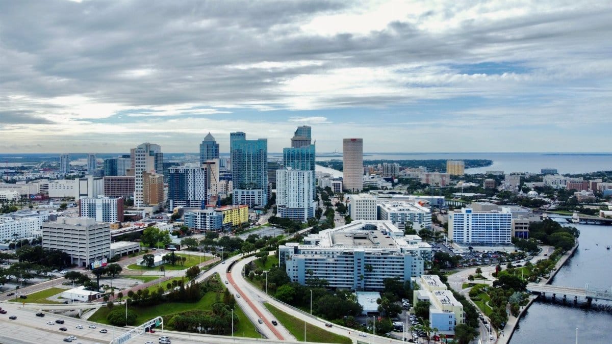A stunning aerial view of Tampa, FL cityscape featuring modern skyscrapers against clouded skies.