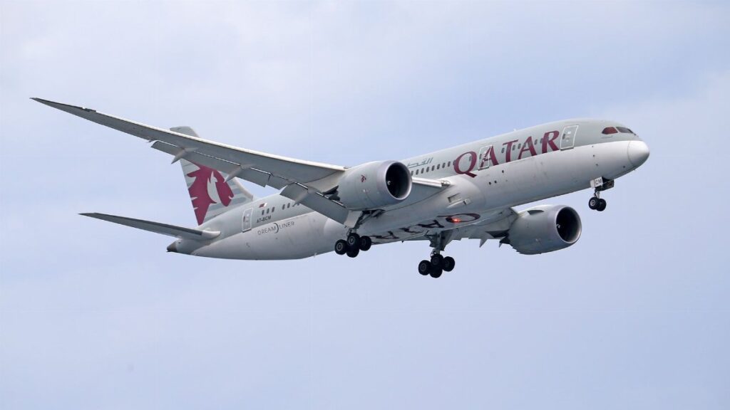 Qatar Airways Boeing 787 soaring against a clear sky, capturing aviation elegance.