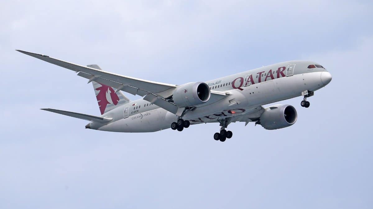 Qatar Airways Boeing 787 soaring against a clear sky, capturing aviation elegance.